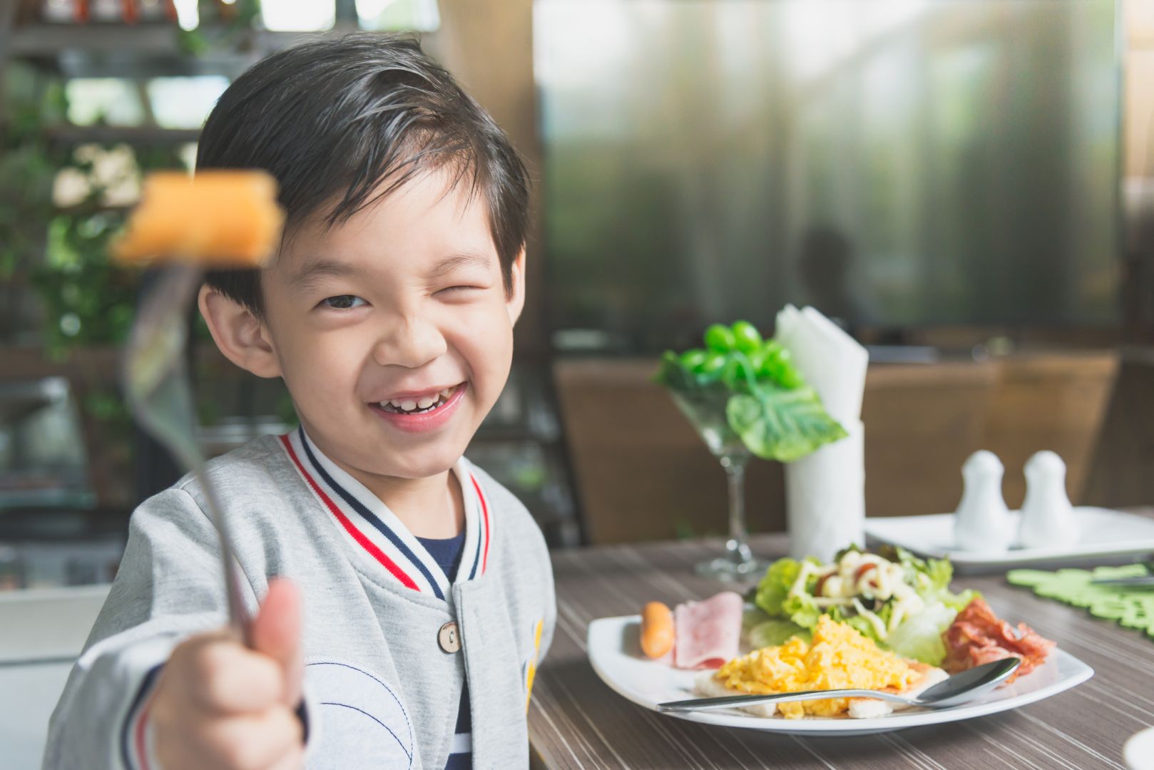 Cute,Asian,Child,Eating,Breakfast,In,A,Restaurant